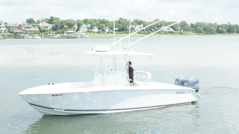 Slide: The Image of A 2012 Jupiter 26 boat on calm water near a residential shoreline. - 2