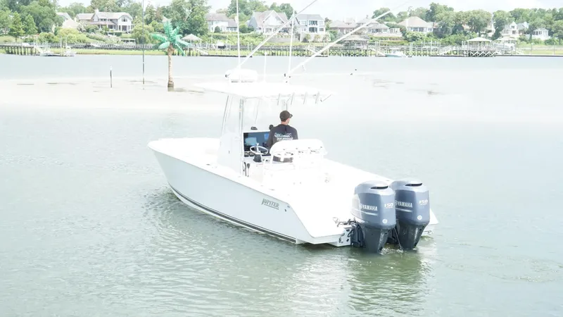 Slide: The Image of A 2012 Jupiter 26 boat with dual Yamaha engines on a calm waterway. - 3