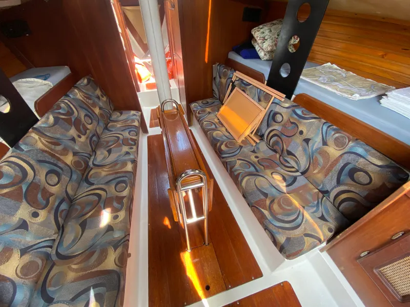 Slide: The Image of Interior of a 1979 Santana 35 sailboat with patterned seating and wooden accents. - 12