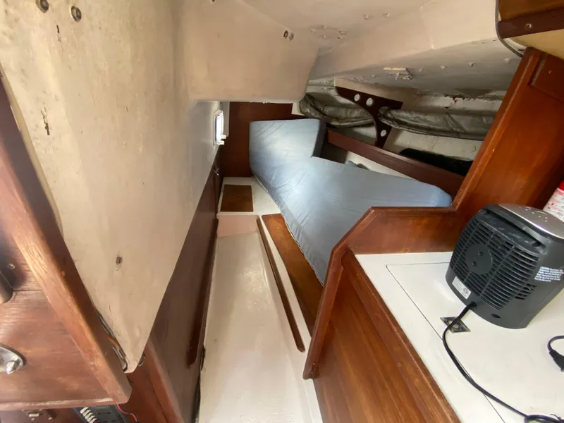 Slide: The Image of Interior cabin of a 1979 Santana 35 sailboat with wooden furnishings and a small fan. - 19