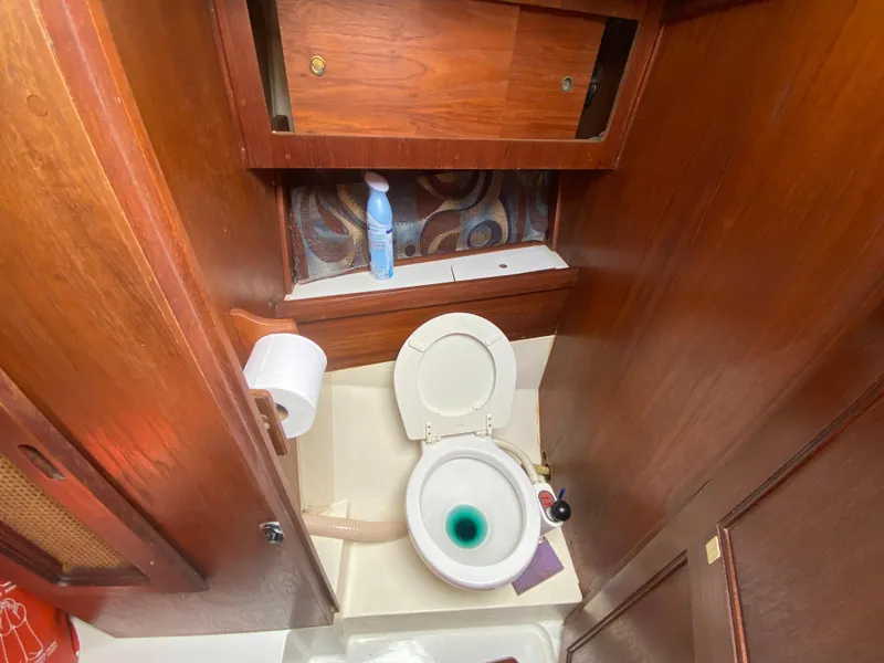 Slide: The Image of 1979 Santana 35 boat bathroom with wooden cabinets and toilet. - 20