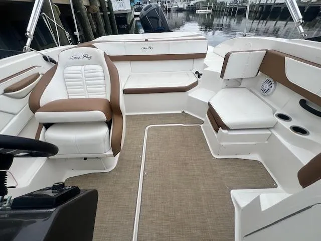Slide: The Image of 2019 Sea Ray SPX 190 OB boat interior with white and brown seating, docked at marina. - 11