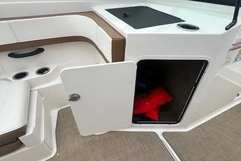 Slide: The Image of 2019 Sea Ray SPX 190 OB boat interior with open storage compartment and visible life jackets. - 14