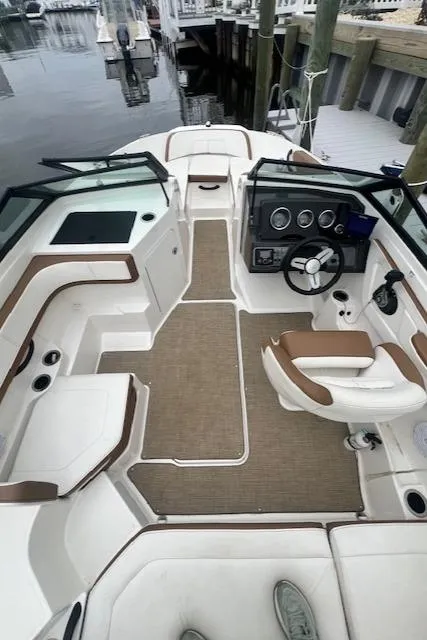 Slide: The Image of 2019 Sea Ray SPX 190 OB boat interior with seating and steering wheel, docked at marina. - 3