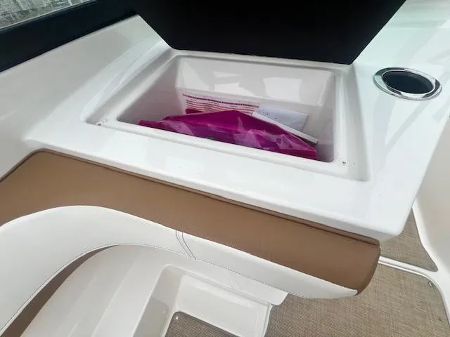 Slide: The Image of 2019 Sea Ray SPX 190 OB boat interior storage compartment with documents and cup holder. - 6