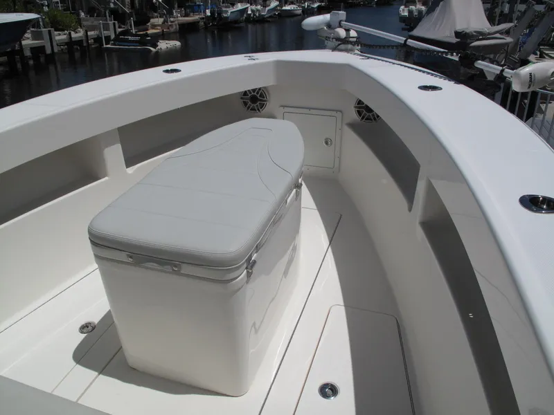 Slide: The Image of 2020 SeaVee 290B boat interior with cushioned seating and storage, docked by the water. - 12