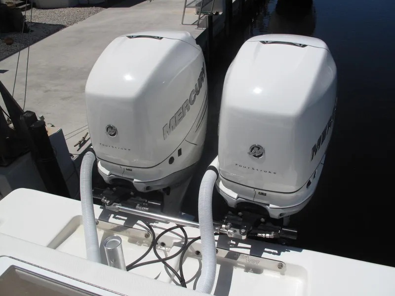 Slide: The Image of Twin Mercury outboard engines on a 2020 SeaVee 290B boat, docked by the water. - 18