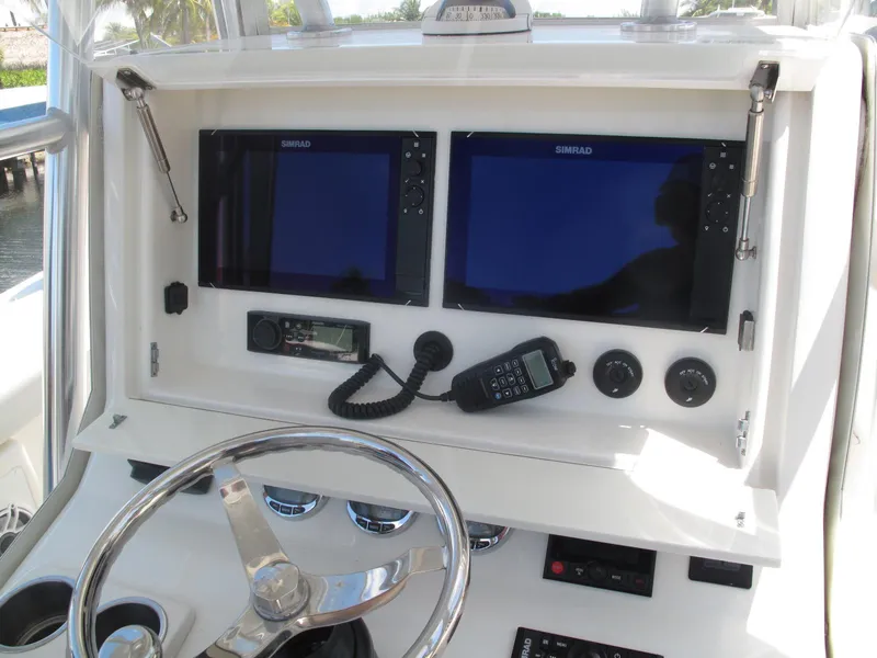 Slide: The Image of 2020 SeaVee 290B boat dashboard with dual Simrad displays and marine radio. - 22