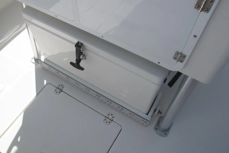 Slide: The Image of 2020 SeaVee 290B boat storage compartment with secure latch and ruler markings. - 26