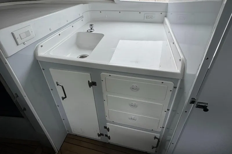 Slide: The Image of 1964 Bertram 31 Flybridge Cruiser interior with sink and storage cabinets. - 12