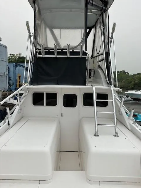 Slide: The Image of 1964 Bertram 31 Flybridge Cruiser with ladder and enclosed flybridge, docked outdoors. - 20