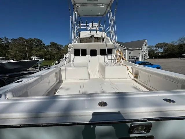 Slide: The Image of 1964 Bertram 31 Flybridge Cruiser with spacious deck and seating, docked under clear skies. - 3