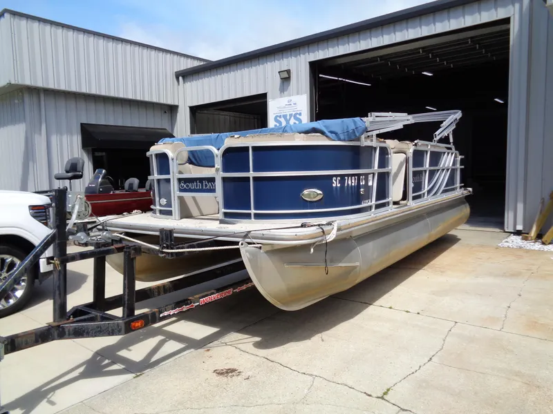 Slide: The Image of 2013 South Bay 422 FCR pontoon boat on trailer outside a metal building. - 3