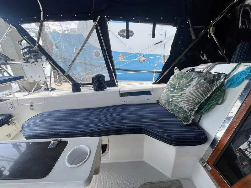 Slide: The Image of 1999 Catalina 42 MkII yacht cockpit with striped cushions and tropical pillows. - 11