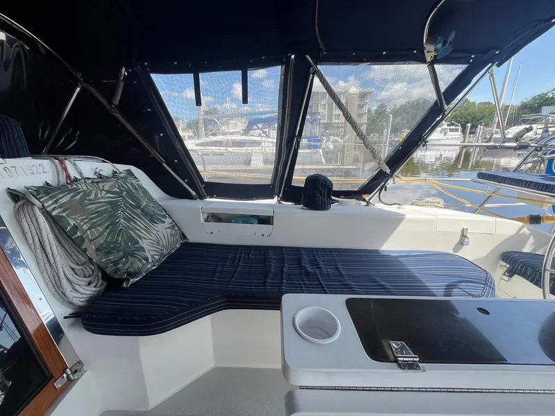 Slide: The Image of Cozy cockpit of 1999 Catalina 42 MkII sailboat with striped seating and tropical pillow. - 12
