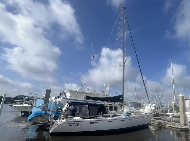 Slide: The Image of 1999 Catalina 42 MkII sailboat docked under a clear blue sky. - 3