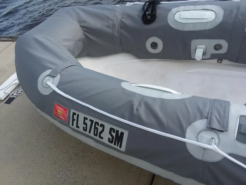 Slide: The Image of Gray inflatable boat with Florida registration FL 5762 SM, docked by the water. - 42
