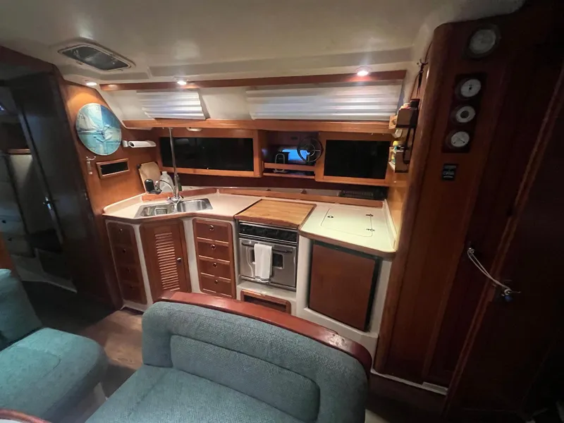 Slide: The Image of Interior of 1999 Catalina 42 MkII yacht, featuring a cozy kitchen and seating area. - 49