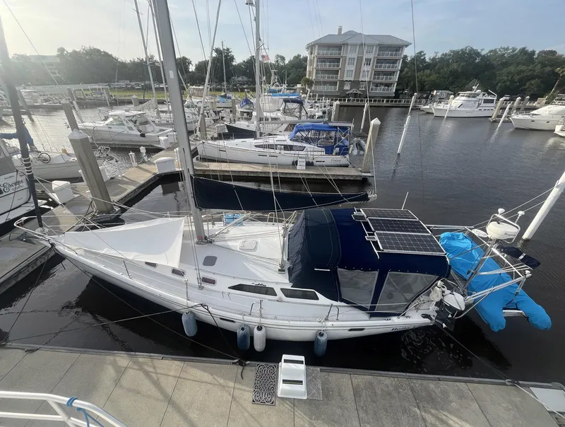 Slide: The Image of Sailboat Catalina 42 MkII, 1999 model, docked at a marina with solar panels. - 6