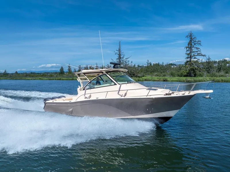 Slide: The Image of 2019 Grady-White Express boat cruising on a scenic lake under a clear blue sky. - 1