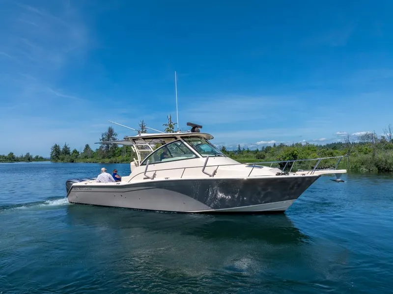 Slide: The Image of 2019 Grady-White Express boat cruising on a serene lake under a clear blue sky. - 2