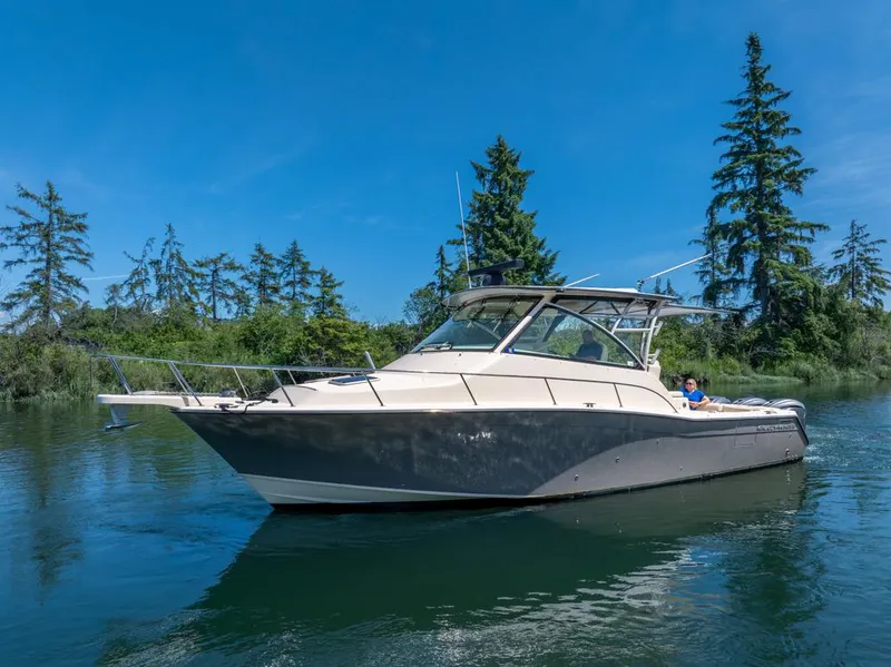 Slide: The Image of 2019 Grady-White Express boat cruising on a serene lake with lush greenery. - 3