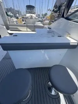Slide: The Image of 2020 Cruisers Yachts 38 GLS interior with seating and table, docked at marina. - 17