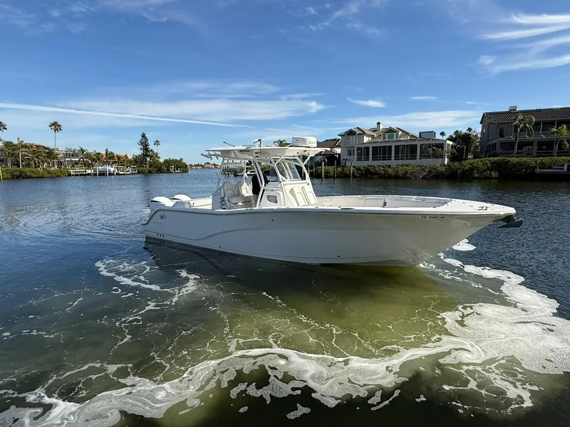 Slide: The Image of 2021 Sea Fox 328 Commander boat cruising on a sunny day near waterfront homes. - 1