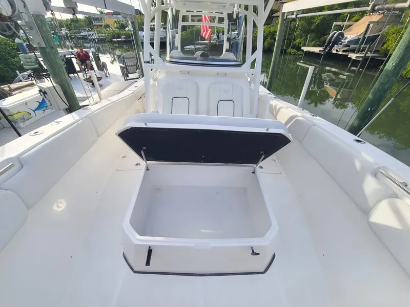 Slide: The Image of 2021 Sea Fox 328 Commander boat with open storage compartment, docked near a waterfront. - 12