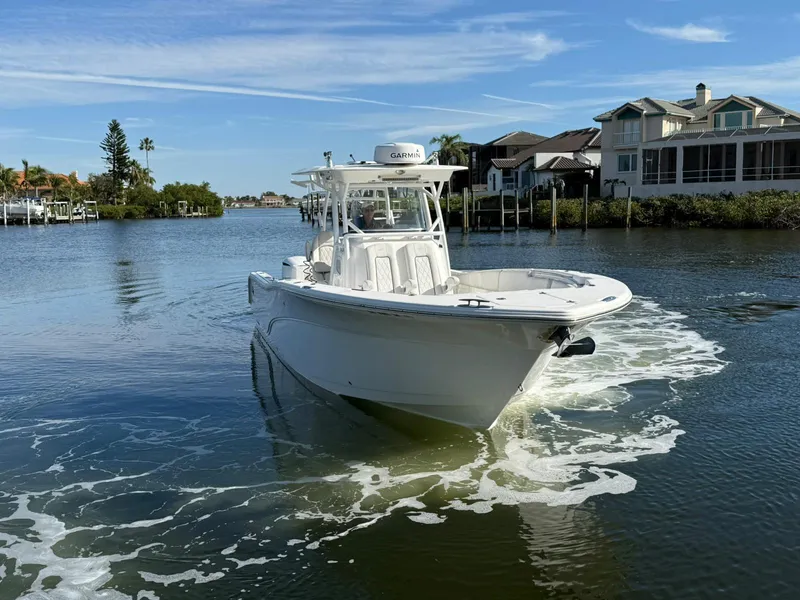 Slide: The Image of 2021 Sea Fox 328 Commander boat cruising on a scenic waterway near waterfront homes. - 2