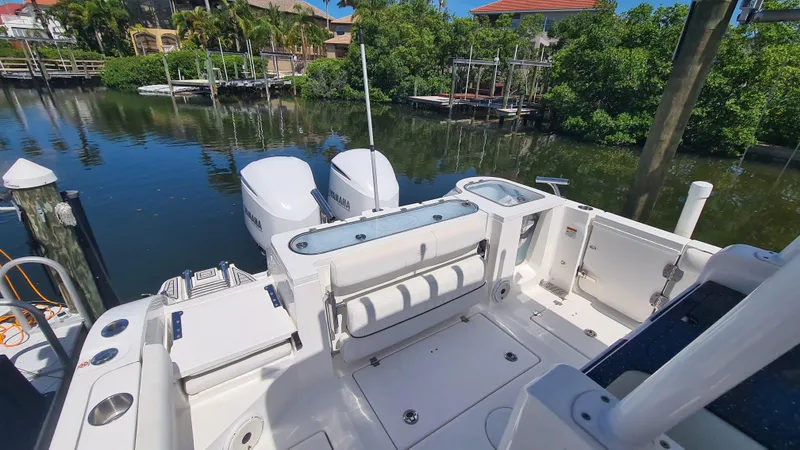 Slide: The Image of 2021 Sea Fox 328 Commander boat with dual Yamaha engines docked by a serene waterfront. - 23