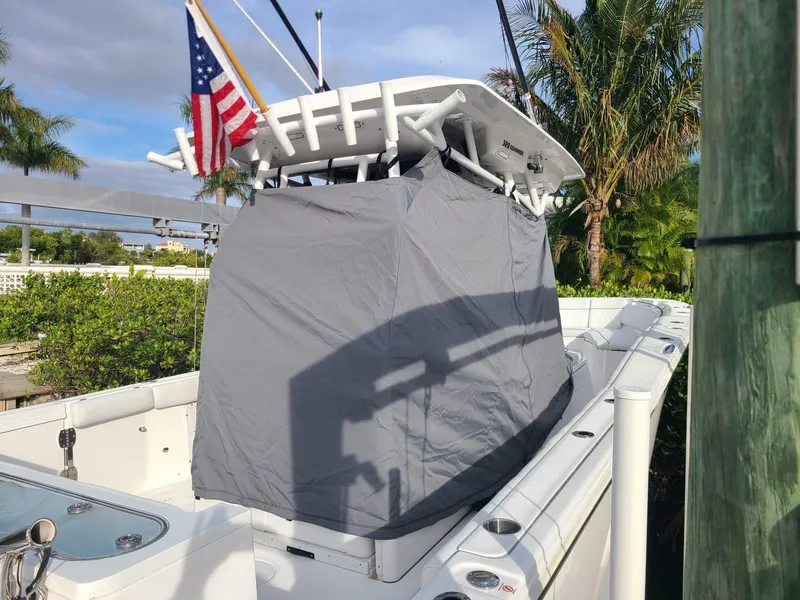 Slide: The Image of 2021 Sea Fox 328 Commander boat with cover, American flag, and tropical background. - 30