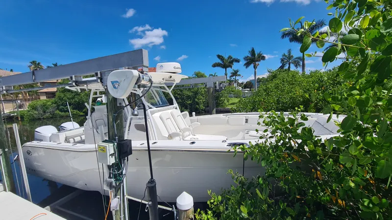 Slide: The Image of 2021 Sea Fox 328 Commander boat docked near lush greenery and clear blue sky. - 5