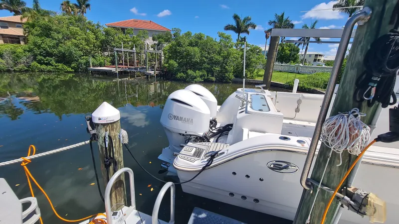 Slide: The Image of 2021 Sea Fox 328 Commander docked by a serene waterfront with lush greenery. - 6