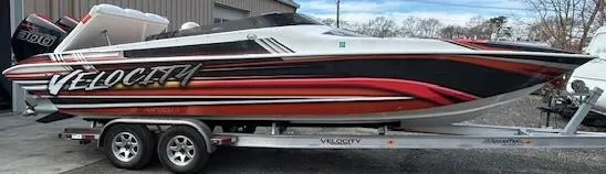 Slide: The Image of 2021 Velocity 290 SC speedboat on trailer, featuring sleek red and black design. - 1