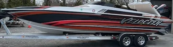Slide: The Image of 2021 Velocity 290 SC speedboat on trailer, featuring sleek red and black design. - 10