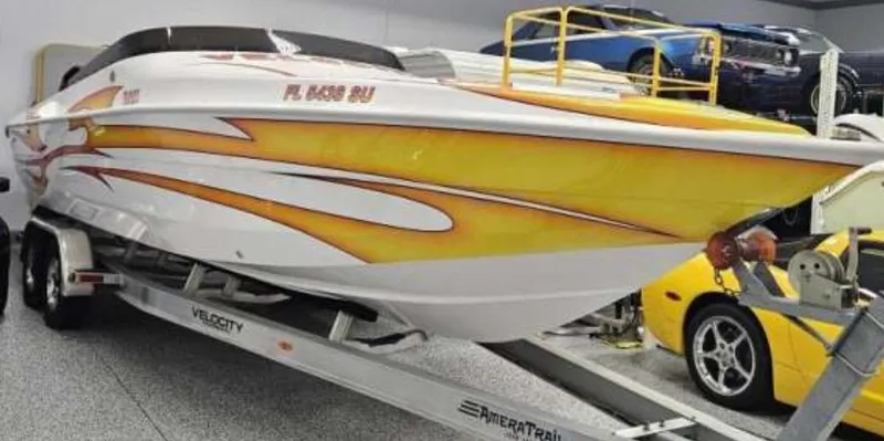 Slide: The Image of 2021 Velocity 290 SC speedboat with vibrant yellow and orange design on a trailer. - 22