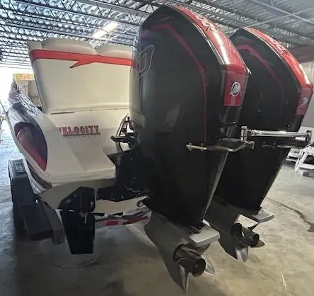 Slide: The Image of 2021 Velocity 290 SC boat with dual outboard motors in a warehouse setting. - 8