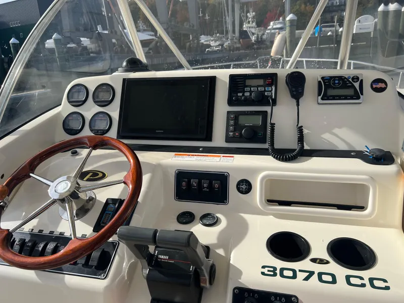 Slide: The Image of 2001 Pursuit 3070 Center Console boat dashboard with steering wheel and navigation instruments. - 15