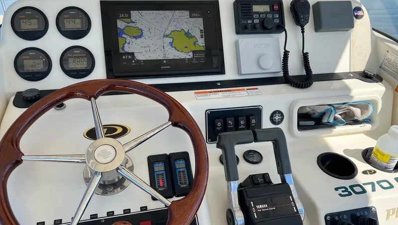 Slide: The Image of 2001 Pursuit 3070 Center Console boat dashboard with navigation and control instruments. - 18