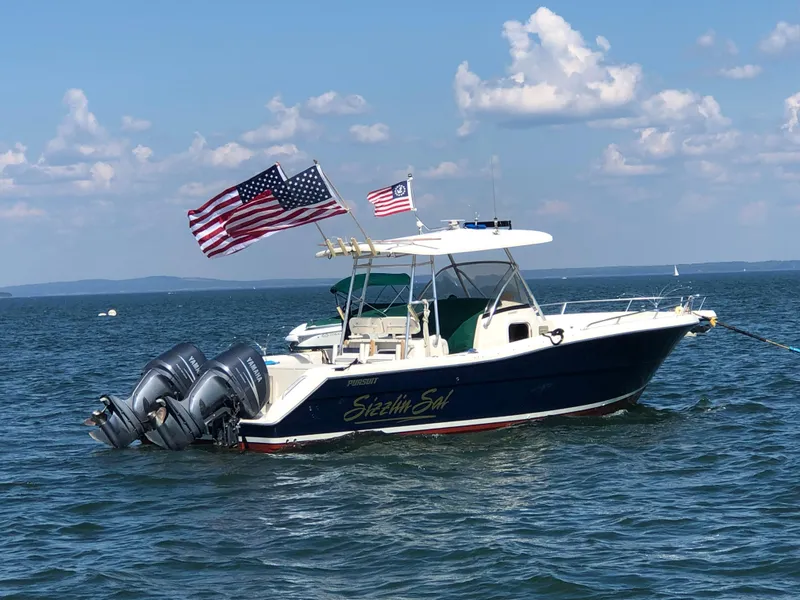 Slide: The Image of 2001 Pursuit 3070 Center Console boat with American flags on open water. - 19