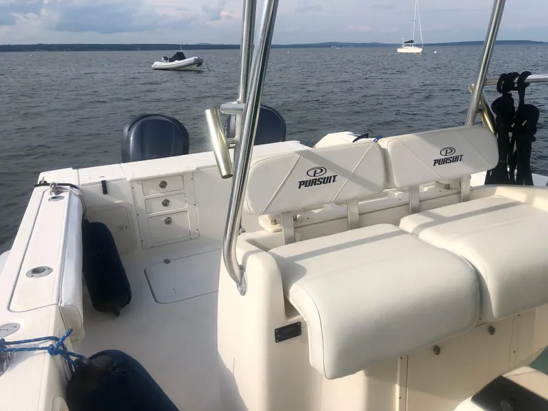 Slide: The Image of 2001 Pursuit 3070 Center Console boat interior with seating, on a calm lake. - 21