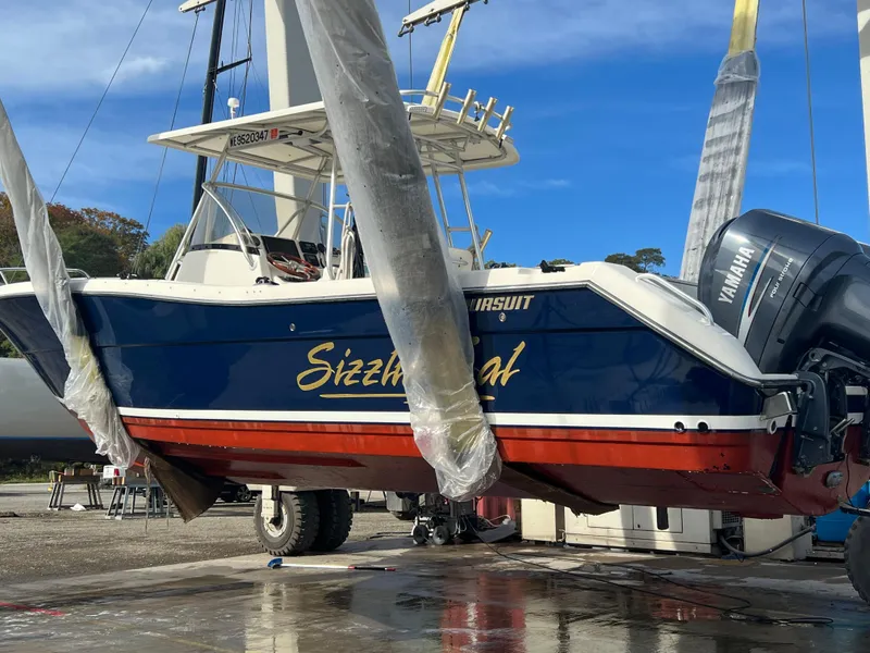 Slide: The Image of 2001 Pursuit 3070 Center Console boat with Yamaha engine, named "Sizzler," on a lift. - 24