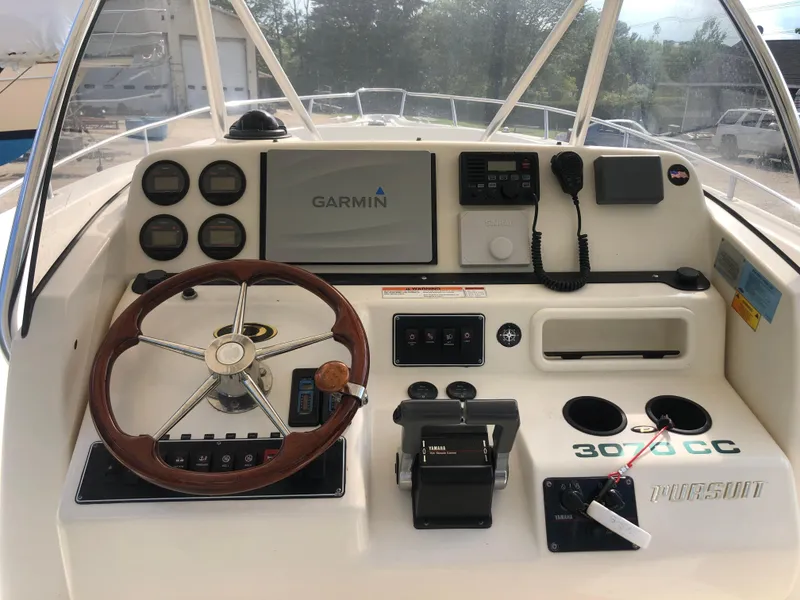 Slide: The Image of 2001 Pursuit 3070 Center Console boat dashboard with Garmin navigation system and controls. - 25