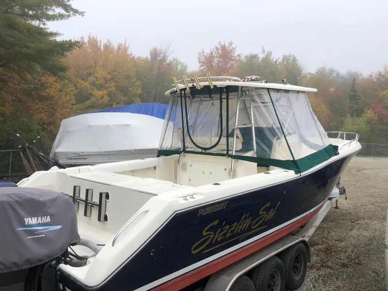 Slide: The Image of 2001 Pursuit 3070 Center Console boat on trailer, surrounded by autumn foliage. - 29