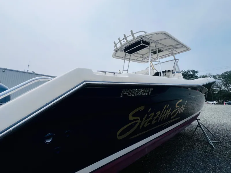 Slide: The Image of 2001 Pursuit 3070 Center Console boat on stands, surrounded by autumn trees. - 37