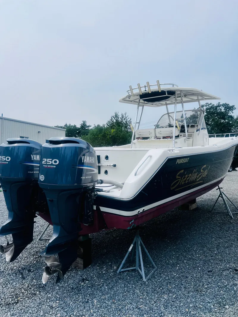 Slide: The Image of 2001 Pursuit 3070 Center Console boat with blue hull, docked outdoors. - 39