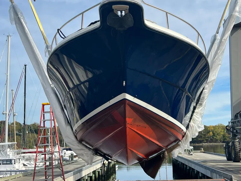 Slide: The Image of 2001 Pursuit 3070 Center Console boat suspended at dockside, showcasing its hull design. - 4