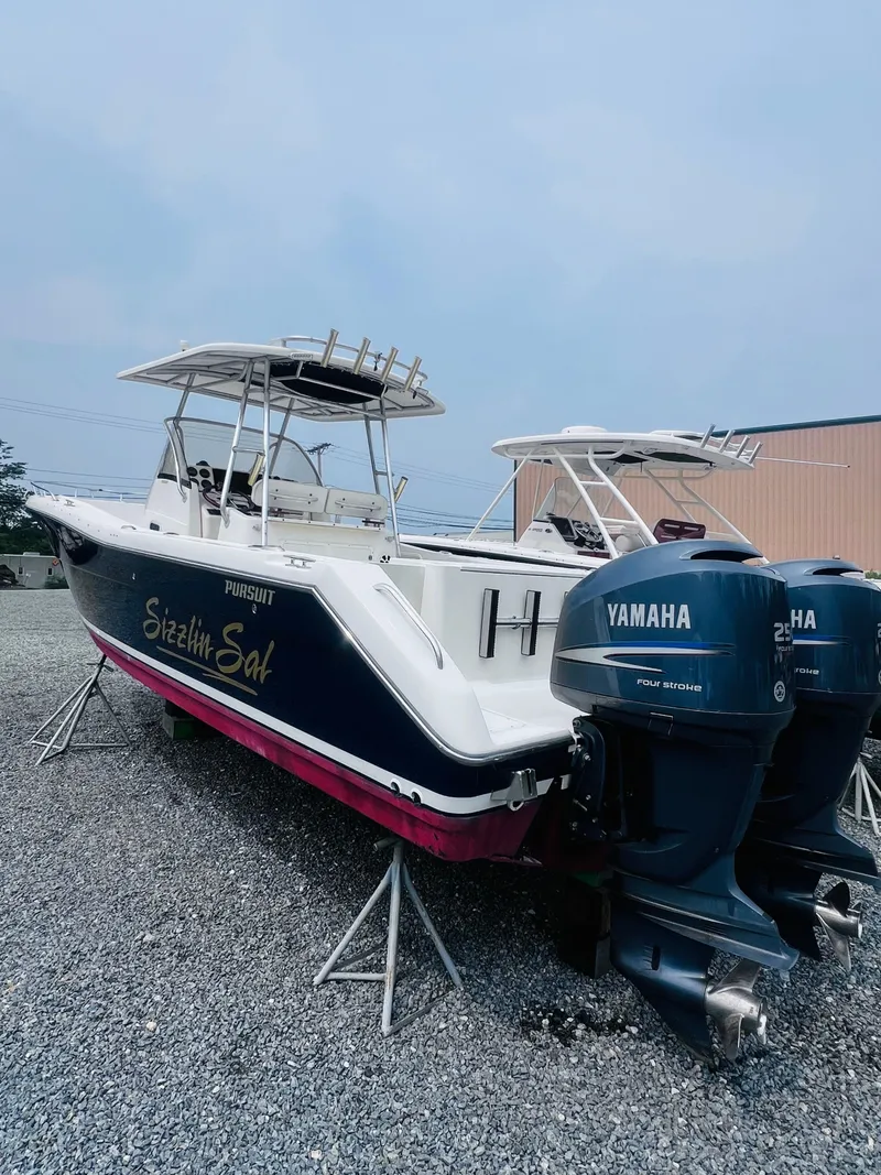 Slide: The Image of 2001 Pursuit 3070 Center Console boat on display, blue hull, red bottom, sunny day. - 40