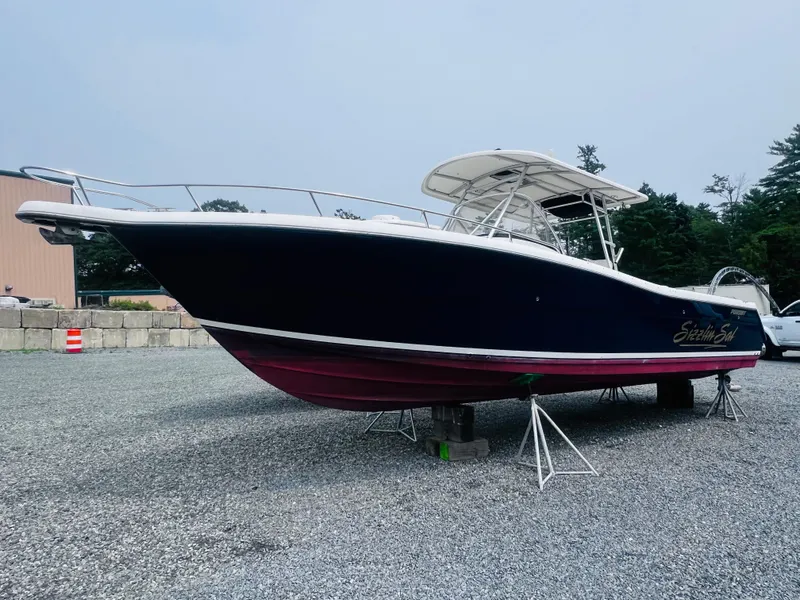 Slide: The Image of 2001 Pursuit 3070 Center Console boat on trailer, blue hull, outdoor storage. - 42